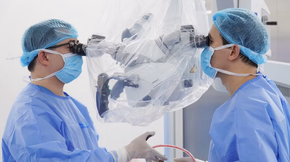 Tiến sĩ Đức Anh (bên phải) và ê-kíp mổ vi phẫu cho người bệnh.