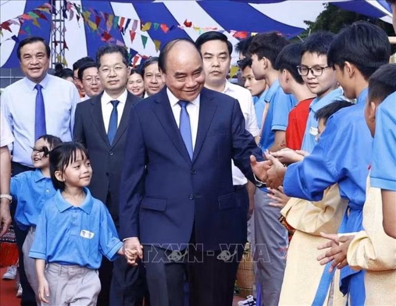 Chủ tịch nước Nguyễn Xuân Phúc với học sinh Trường Tiểu học, Trung học cơ sở và Trung học phổ thông Hy Vọng. (Ảnh TTXVN)