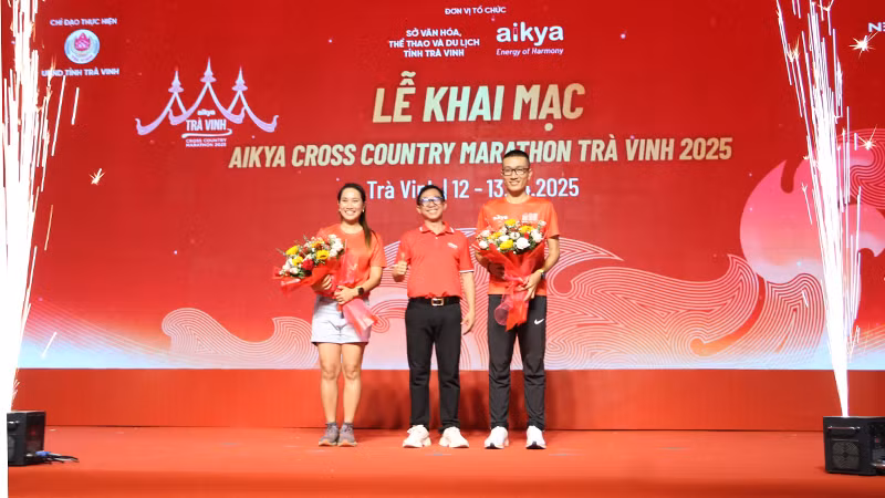Thanh Vũ, Minh Đức - hai đại sứ giải Aikya Cross Country Marathon Trà Vinh 2025, nhận hoa từ Ban Tổ chức giải.