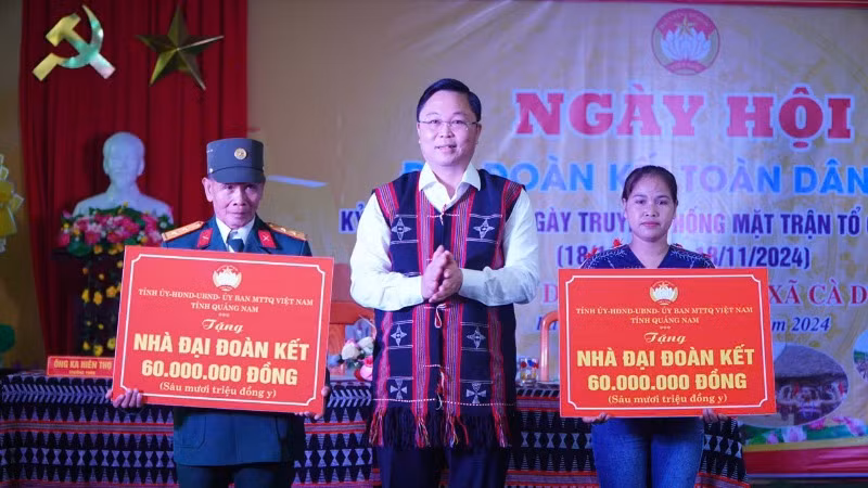 Chủ tịch Ủy ban MTTQ Việt Nam tỉnh Quảng Nam Lê Trí Thanh (ở giữa) trao bảng tượng trưng hỗ trợ xây dựng 2 nhà đại đoàn kết cho hộ nghèo tại ngày hội đại đoàn kết năm 2024 ở huyện Nam Giang.