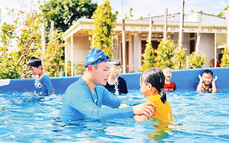 Thầy giáo Mai Văn Chuyền dạy bơi miễn phí cho các học sinh ở thôn Hiệp Hưng, xã Quảng Hiệp, huyện Cư M’gar, tỉnh Đắk Lắk (Ảnh CÔNG LÝ) Thầy giáo Mai Văn Chuyền dạy bơi miễn phí cho các học sinh ở thôn Hiệp Hưng, xã Quảng Hiệp, huyện Cư M’gar, tỉnh Đắk Lắk (Ảnh CÔNG LÝ)