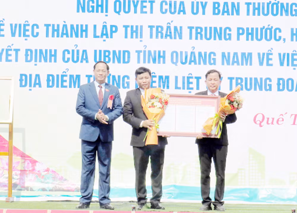 Phó Chủ tịch Quốc hội Trần Quang Phương trao Nghị quyết thành lập thị trấn Trung Phước cho đại diện lãnh đạo địa phương.