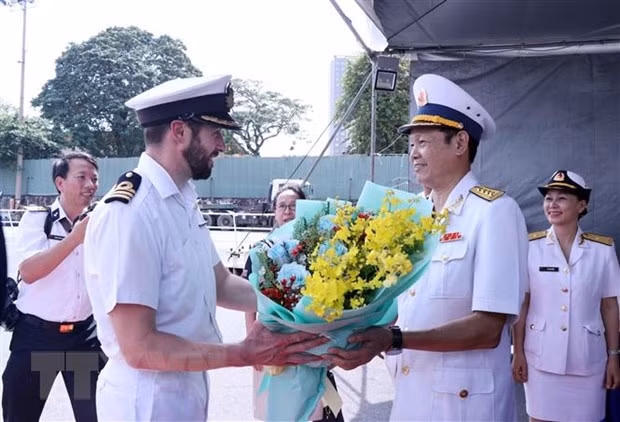 Đại tá Lê Nam Sơn (phải), Phó Lữ đoàn trưởng Lữ đoàn 125, Bộ Tư lệnh Vùng 2 Hải quân đại diện lãnh đạo Quân chủng Hải quân Việt Nam tặng hoa, đón Trung tá Michael Proudman (trái), thuyền trưởng chỉ huy tàu HMS Spey. (Ảnh: Xuân Khu/TTXVN)