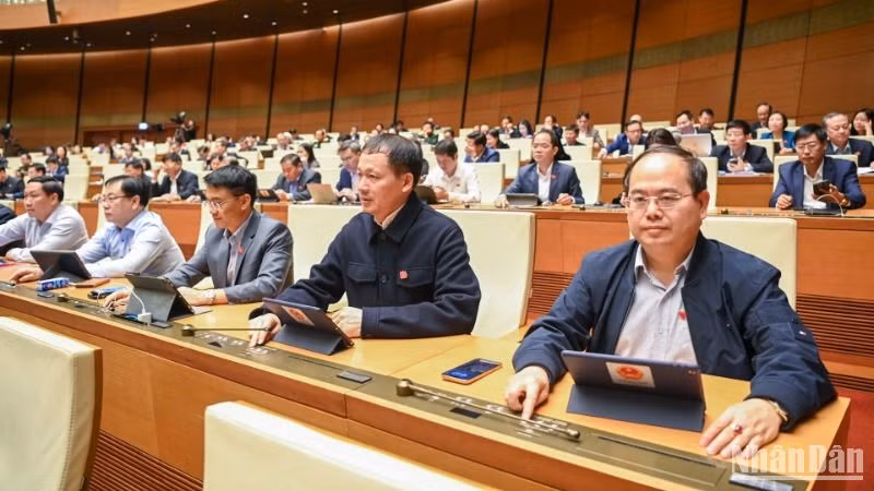Các đại biểu bấm nút thông qua Nghị quyết về thí điểm xử lý vật chứng, tài sản trong quá trình điều tra, truy tố, xét xử một số vụ việc, vụ án hình sự. (Ảnh: DUY LINH) 