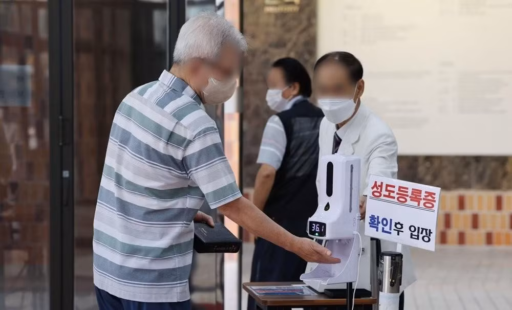 Kiểm tra thân nhiệt trước khi vào nhà thờ ở Seoul, Hàn Quốc, ngày 17/7/2022. (Ảnh: Yonhap)