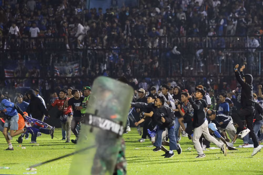 Các cổ động viên quá khích tràn vào sân vận động Kanjuruhan sau khi Arema FC để thua Persebaya với tỷ số 2-3 trong trận đấu tối 1/10/2022. (Ảnh: AP)
