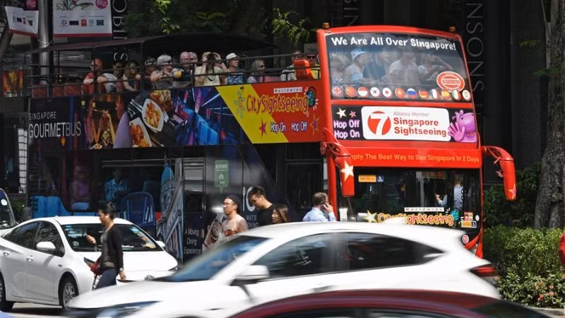 Xe buýt chở khách du lịch trên đường phố Singapore. (Ảnh: Xinhua)