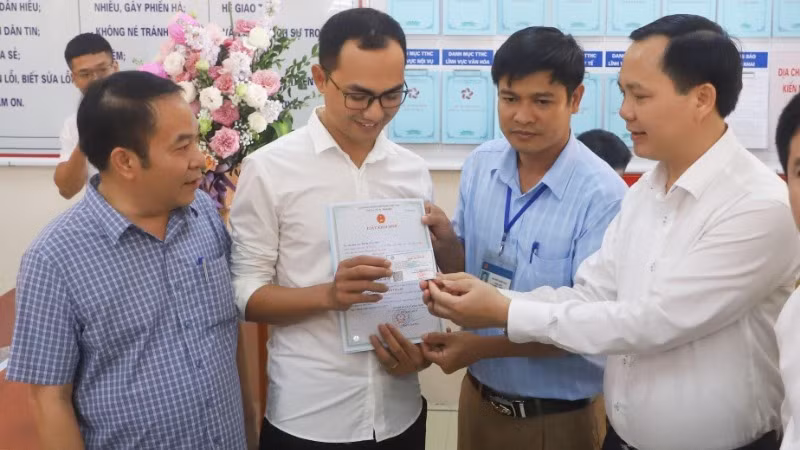 Trao giấy khai sinh và thẻ bảo hiểm y tế theo dịch vụ công liên thông giữa cơ sở dữ liệu về hộ tịch và bảo hiểm. (Ảnh minh họa: TTXVN)