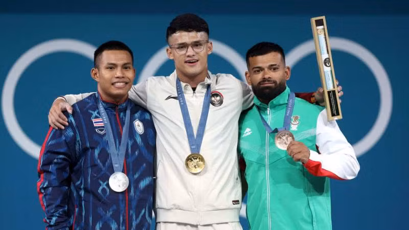 Hai đô cử Đông Nam Á - Rizki Juniansyah của Indonesia (HCV) và Weeraphon Wichuma của Thái Lan (trái) giành Huy chương Bạc trên bục nhận huy chương cùng chủ nhân tấm Huy chương Đồng Bozhidar Dimitrov Andreev của Bulgaria (phải) sau nội dung cử tạ 73kg nam. (Ảnh: Getty Images) Hai đô cử Đông Nam Á - Rizki Juniansyah của Indonesia (HCV) và Weeraphon Wichuma của Thái Lan (trái) giành Huy chương Bạc trên bục nhận huy chương cùng chủ nhân tấm Huy chương Đồng Bozhidar Dimitrov Andreev của Bulgaria (phải) sau nội dung cử tạ 73kg nam. (Ảnh: Getty Images)