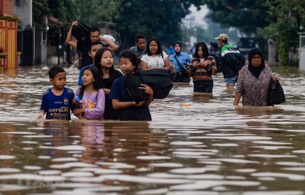 Sơ tán người dân khỏi khu vực ngập lụt tại Indonesia. (Ảnh: AFP/TTXVN)