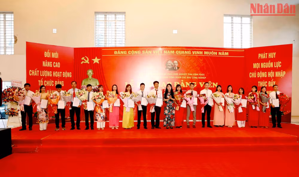 Bí thư Tỉnh ủy Hoàng Thị Thúy Lan trao quyết định kết nạp đảng và tặng hoa cho các đảng viên mới.