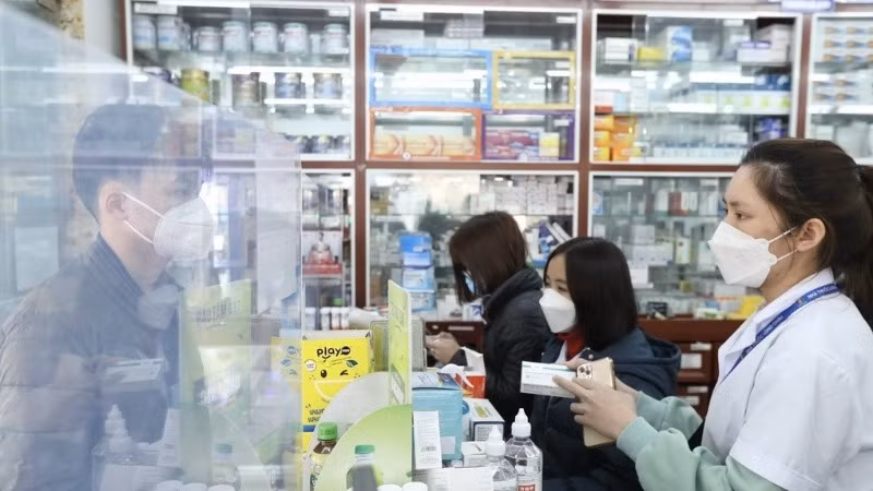 Nhân viên cửa hàng thuốc hướng dẫn khách sử dụng thuốc. (Ảnh minh họa: TTXVN) 