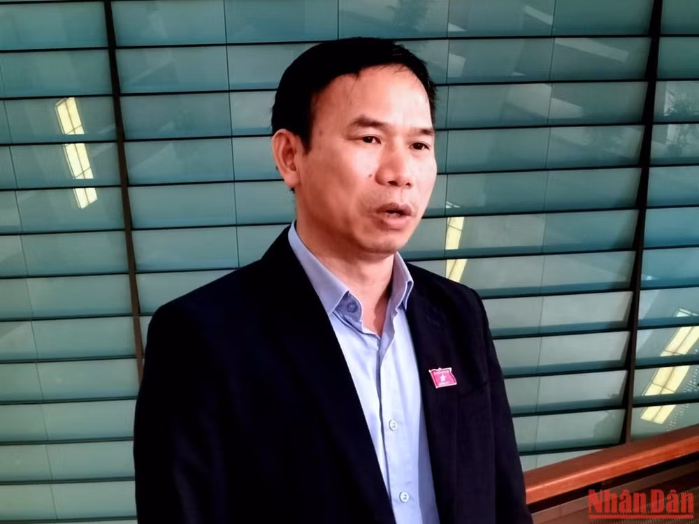 Đại biểu Đồng Ngọc Ba (Bình Định) trao đổi bên hành lang Quốc hội. (Ảnh: TRUNG HƯNG)