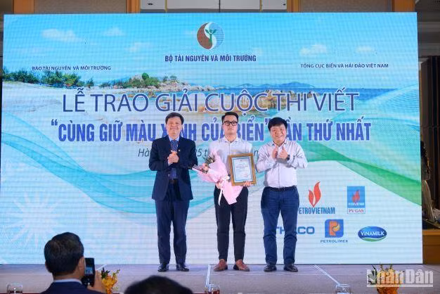 Phó Tổng Biên tập Báo Nhân Dân Quế Đình Nguyên (ngoài cùng bên phải) và Phó Chủ nhiệm Ủy ban Khoa học, Công nghệ và Môi trường của Quốc hội Tạ Đình Thi trao giải và tặng hoa cho tác giả đoạt giải Nhì.