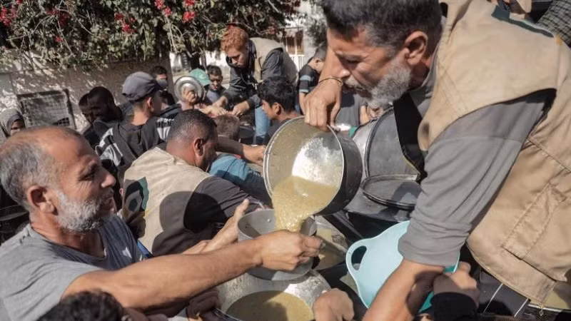 Người dân được phát thực phẩm cứu trợ tại Deir al-Balah, Dải Gaza hồi tháng 11/2024. (Ảnh: THX/TTXVN)