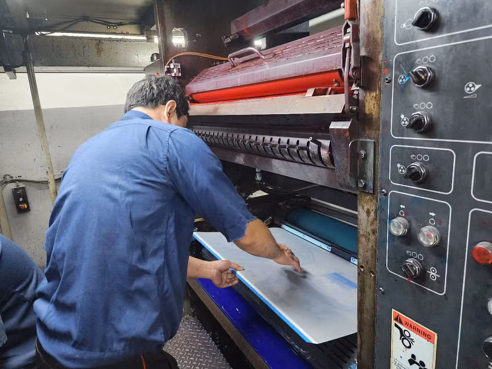 Công nhân nhà in Báo Nhân Dân lắp bản kẽm ấn phẩm phụ san đặc biệt kỷ niệm 50 năm Ngày Giải phóng miền nam, thống nhất đất nước lên máy in