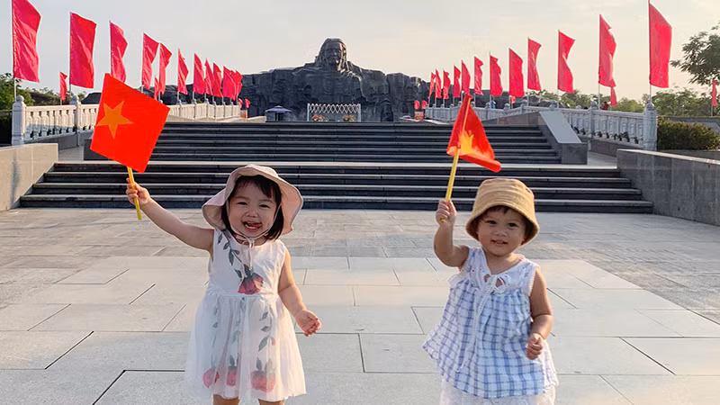 Các em nhỏ được gia đình đưa đến tham quan Tượng đài Bà mẹ Việt Nam Anh hùng.