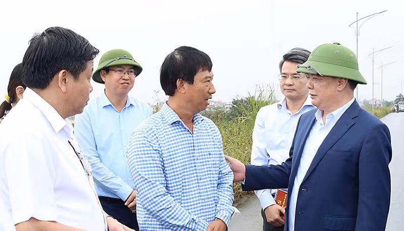 Đồng chí Đinh Tiến Dũng trò chuyện với người dân có đất nằm trong dự án Vành đai 4-Vùng Thủ đô trên địa bàn huyện Hoài Đức.
