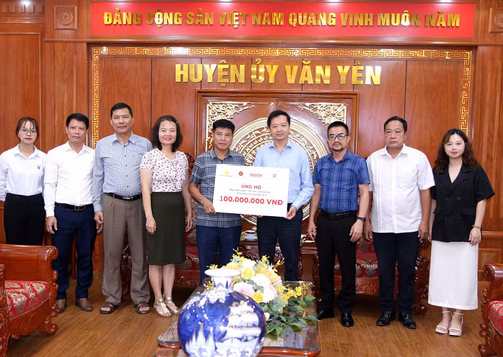 Đại diện Báo Nhân Dân, các nhà tài trợ và lãnh đạo Ủy ban nhân dân huyện Văn Yên, tỉnh Yên Bái, trao và nhận biểu trưng hỗ trợ nhân dân huyện Văn Yên, tỉnh Yên Bái. (Ảnh: THANH SƠN)