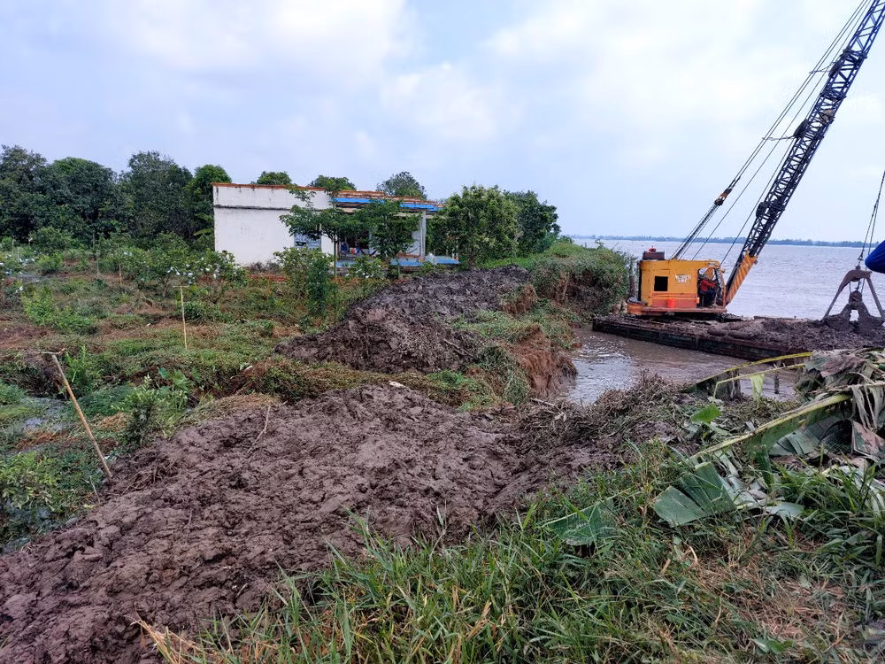 Thực hiện phương châm “4 tại chỗ” huy động phương tiện gia cố tạm thời khu vực sạt lở tại cồn Thanh Long vào chiều 21/4. 