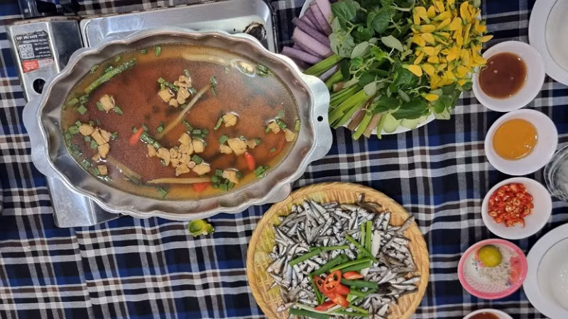 Cá linh non kho lạt ăn kèm bông điên điển là món đặc sản mùa nước nổi miền Tây.