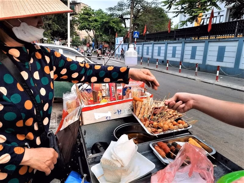 Những quán hàng rong với nhiều loại thức ăn, nước uống được bày bán tại khu vực cổng trường học không bảo đảm vệ sinh an toàn thực phẩm. (Ảnh ĐỖ VI)