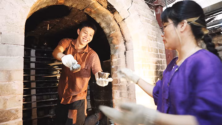 Nghệ nhân Nguyễn Văn Huân cùng bạn nghề dỡ mẻ gốm mới.