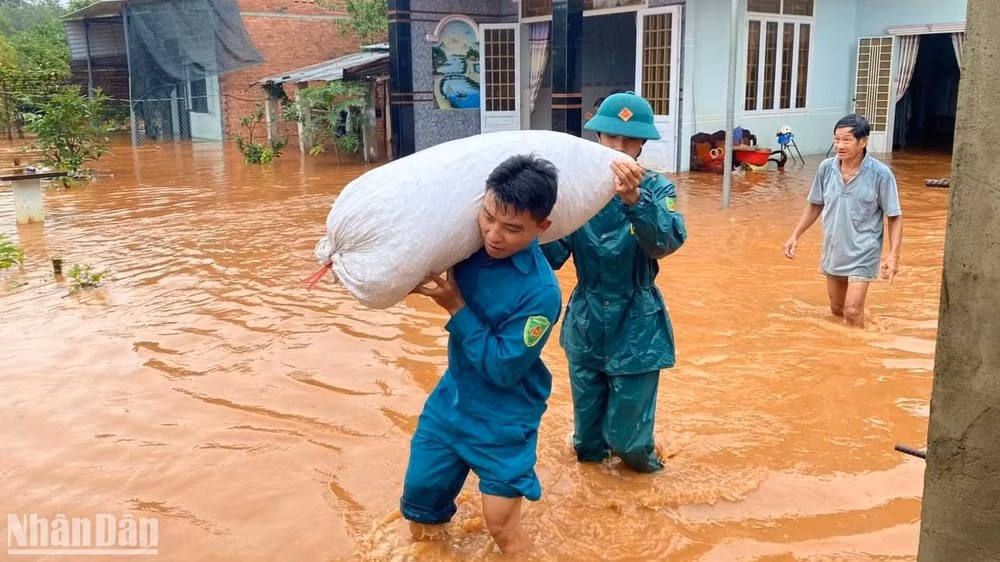 Lực lượng dân quân hỗ trợ người dân di dời các vật dụng ra khỏi khu vực ngập nước.