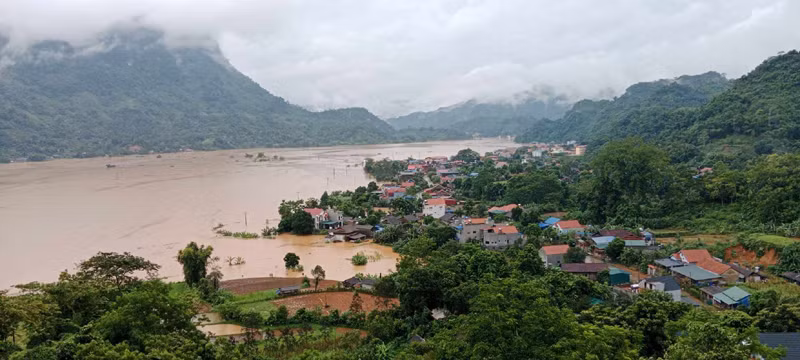 Nước ngập cánh đồng và cả nhà dân. (Ảnh: TUẤN SƠN)