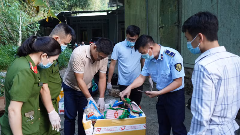 Lực lượng chức năng kiểm tra thực phẩm đông lạnh hết hạn sử dụng vừa phát hiện. (Ảnh: NGỌC ÁNH).