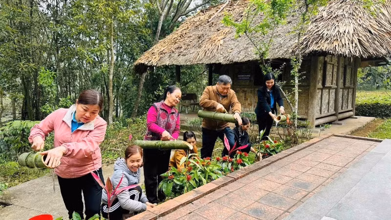 Người dân xã Lương Bằng (Chợ Đồn) chăm sóc hoa, cây cảnh trong di tích Nà Pậu. (Ảnh: NÔNG VUI)