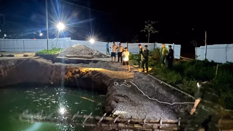 Lực lượng chức năng và người dân tìm kiếm tại khu vực hố sụt trong đêm 26/7. (Ảnh: TUẤN SƠN).