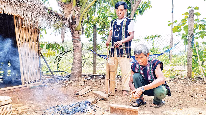 Nghệ nhân Điểu K’Bôi truyền dạy nghề rèn cho con trai.