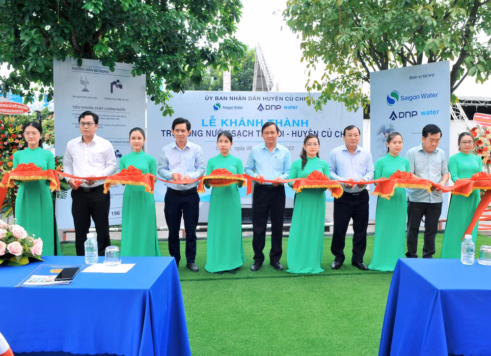 Đại diện ban lãnh đạo huyện Củ Chi và các nhà tài trợ cùng cắt băng khánh thành trụ nước uống sạch cộng đồng.