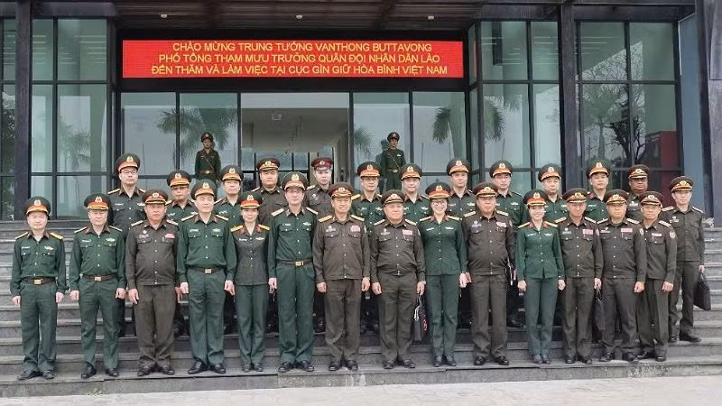 Đoàn đại biểu Bộ Quốc phòng nước Cộng hòa Dân chủ Nhân dân Lào chụp ảnh kỷ niệm với cán bộ, chiến sĩ Cục Gìn giữ hòa bình Việt Nam.