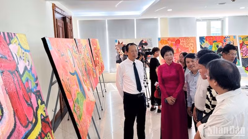 Các đại biểu và khán giả chiêm ngưỡng bộ tranh của hoạ sĩ Phạm Hải Nguyên được trưng bày.