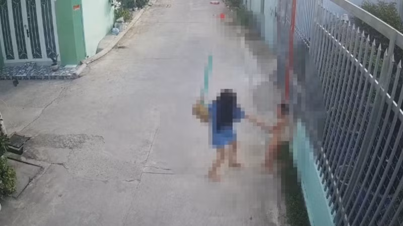 Bà Trang dùng chổi đánh cháu T. (Ảnh cắt từ camera)