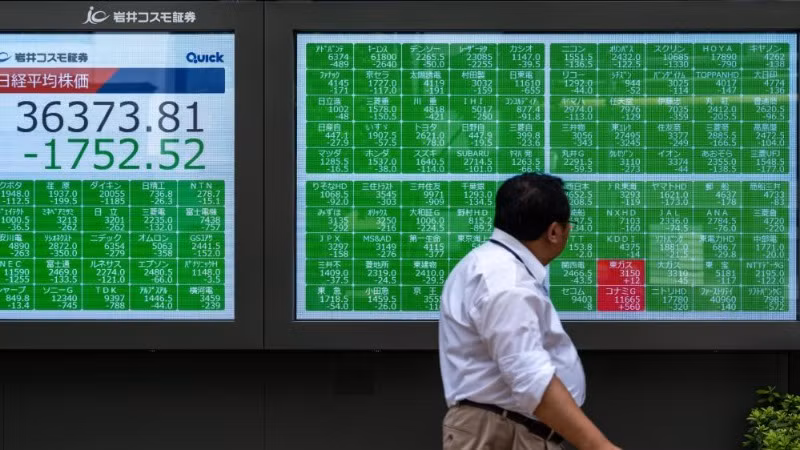 Một người đi bộ ngang qua màn hình hiển thị thông tin thị trường chứng khoán tại Tokyo, Nhật Bản, ngày 2/8/2024. (Ảnh minh họa: Tân Hoa xã)