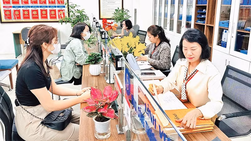 Người dân thực hiện giải quyết thủ tục hành chính tại Bộ phận một cửa quận Đống Đa, Hà Nội. (Ảnh minh họa: NGUYÊN BẢO)