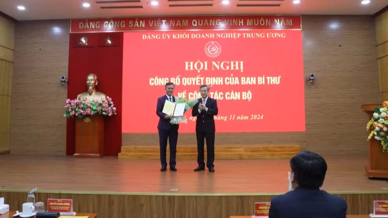 Đồng chí Nguyễn Quang Dương trao quyết định, tặng hoa chúc mừng đồng chí Trần Thắng.