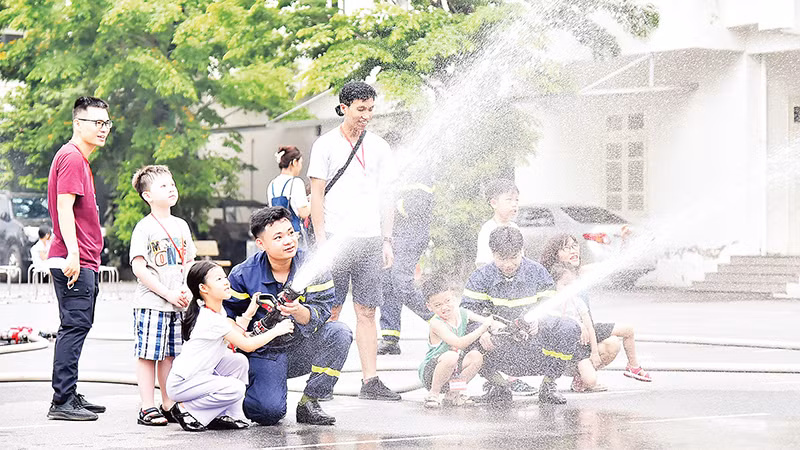 Các em học sinh tham gia thực hành cùng cán bộ, chiến sĩ Trường đại học Phòng cháy chữa cháy. (Ảnh MỸ HÀ) 