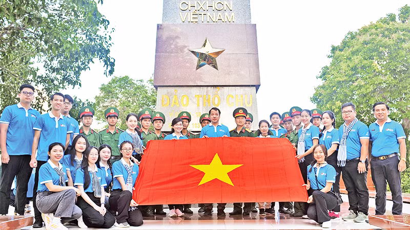 Các đại biểu cùng cán bộ, chiến sĩ tại cột mốc chủ quyền đảo Thổ Châu, một công trình do Trung ương Ðoàn, Trung ương Hội Sinh viên Việt Nam xây dựng. 