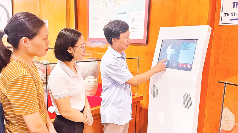 Cán bộ, nhân viên Bảo tàng tỉnh Nam Ðịnh trao đổi kinh nghiệm vận hành máy tra cứu thông tin hiện vật 3D. 