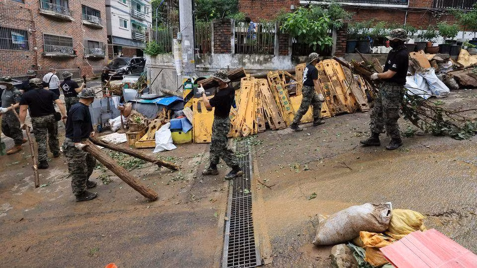 Binh sĩ dọn dẹp đường phố Seoul sau trận mưa kỷ lục ngày 9/8. (Ảnh: Yonhap)