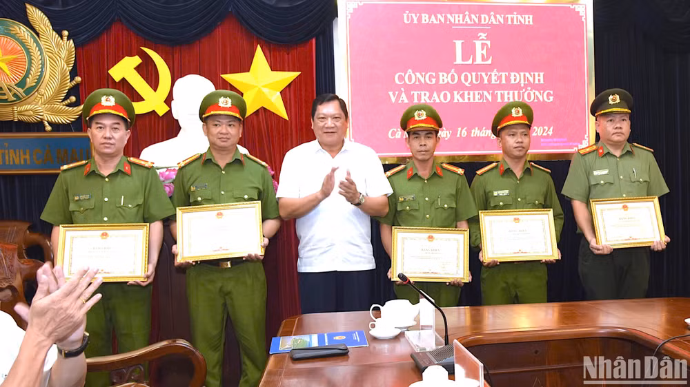 Phó Chủ tịch Ủy ban nhân dân tỉnh Cà Mau Lâm Văn Bi (áo trắng) tặng Bằng khen của Chủ tịch Ủy ban nhân dân tỉnh cho tập thể, cá nhân phá nhanh chuyên án 724T.