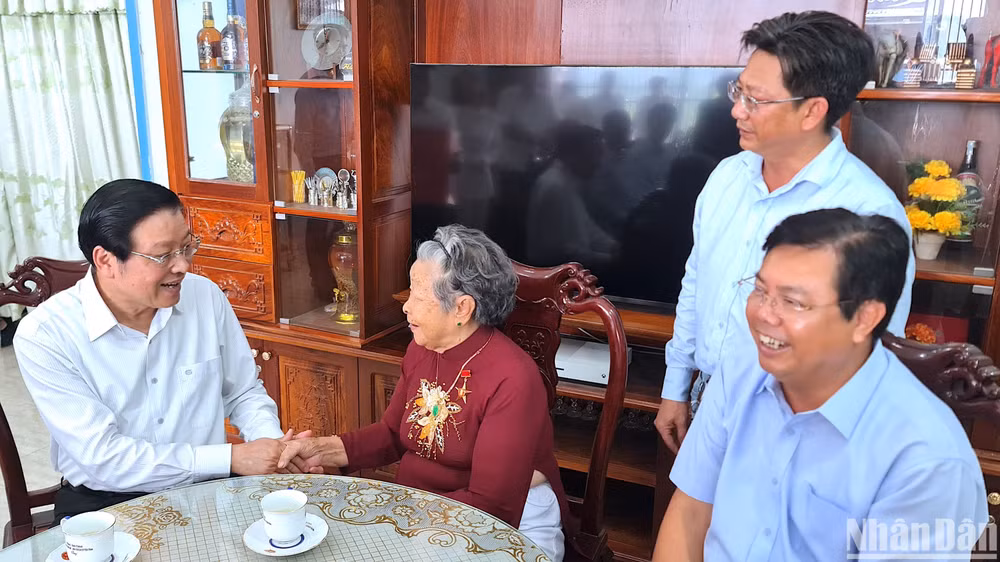 Đồng chí Phan Đình Trạc (bía trái) thăm hỏi sức khỏe Mẹ Việt Nam Anh hùng Nguyễn Kim Mai (thành phố Cà Mau).