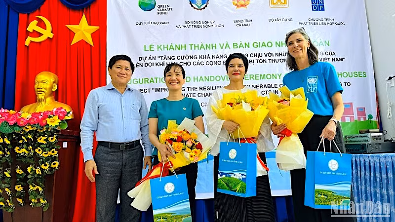 Đại diện lãnh đạo tỉnh Cà Mau tặng hoa cảm ơn các đơn vị đồng hành hỗ trợ nhà cho cư dân vùng ven biển.