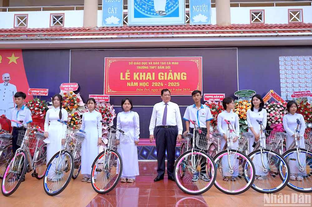 Phó Chủ tịch Ủy ban nhân dân tỉnh Cà Mau Lâm Văn Bi (giữa) trao tặng xe đạp cho các học sinh khó khăn Trường THPT Đầm Dơi (huyện Đầm Dơi, tỉnh Cà Mau) vào sáng 5/9.