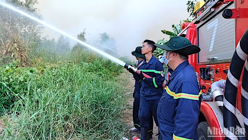 Lực lượng chức năng tiếp tục phun nước dập cháy ngún tại Nông trường 402 vào sáng 11/4.