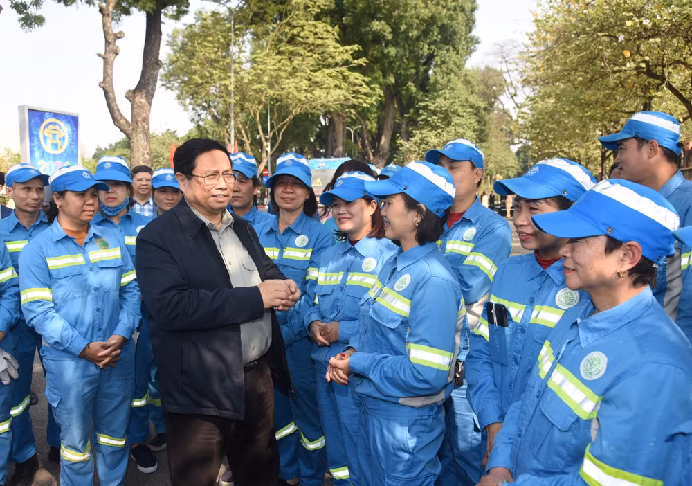 Thủ tướng Phạm Minh Chính thăm hỏi công nhân Tổ vệ sinh môi trường đang làm việc tại khu vực Đài tưởng niệm các Anh hùng liệt sĩ trên đường Hoàng Diệu. Ảnh: TRẦN HẢI
